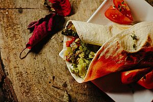 Mexikanischer Wrap auf einem Teller mit Tomaten